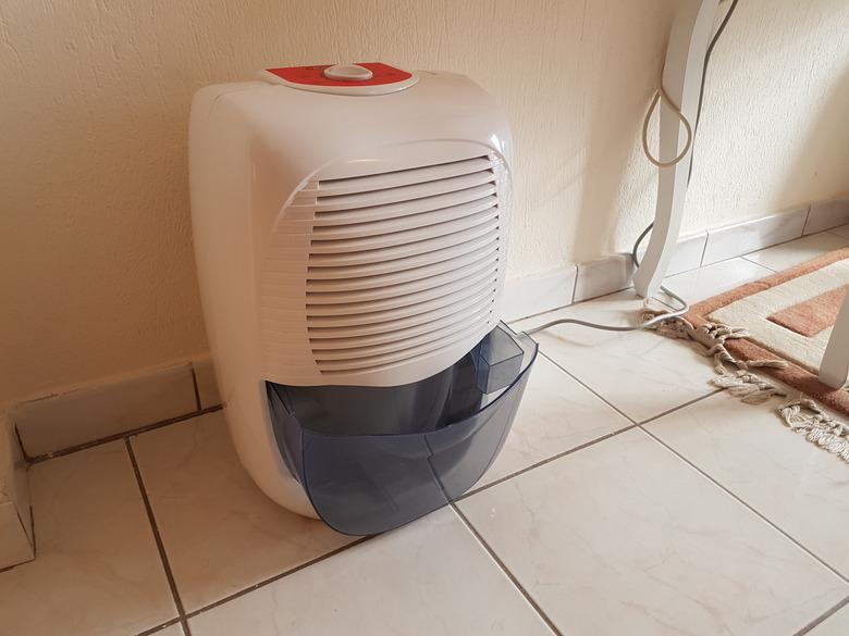 dehumidifier  in the room on the floor white red plastic