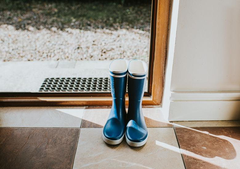 Blue Welly boots sitting by an open back door.