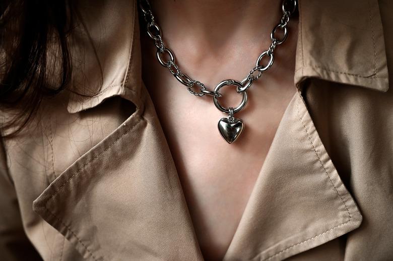 Person wearing a silver heart-shaped necklace.