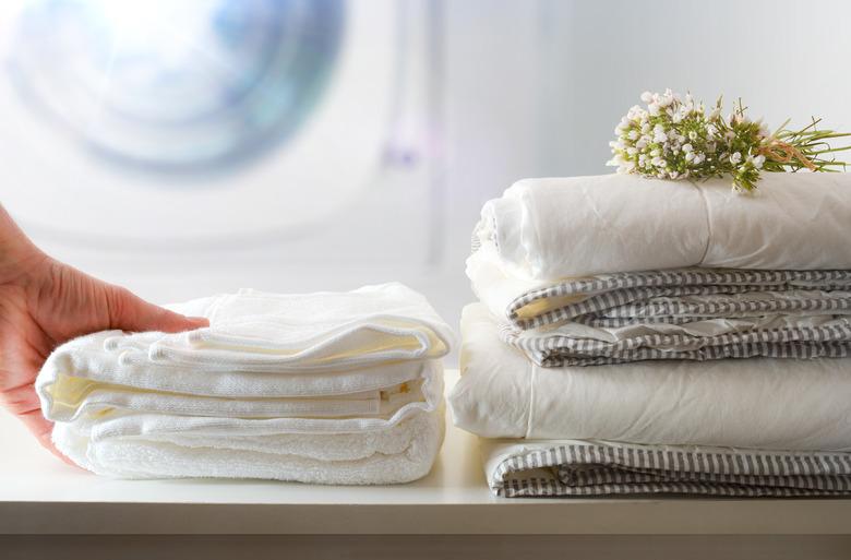 Clean bedding, washing machine in background.