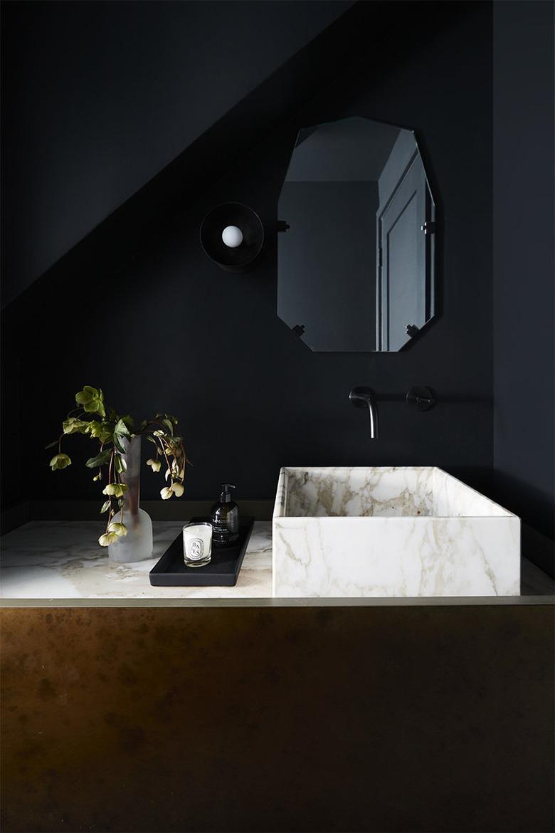 black bathroom with marble vessel sink and black fixtures