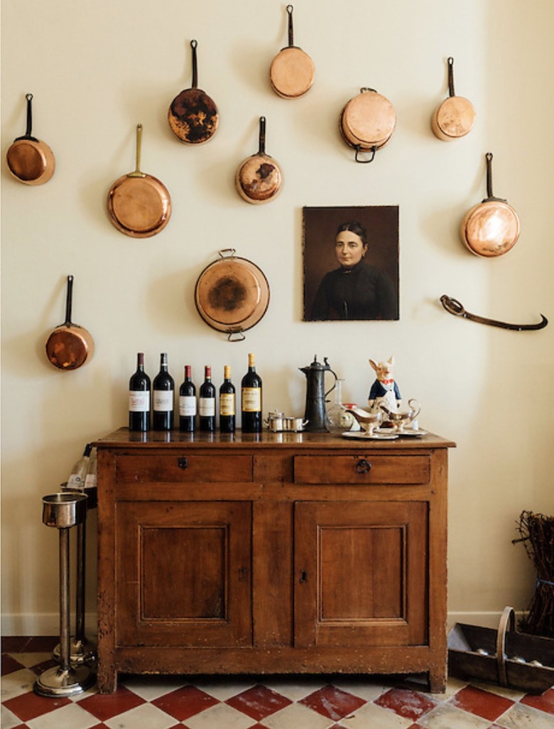 Eclectic kitchen with yellow walls and hanging copper pots.