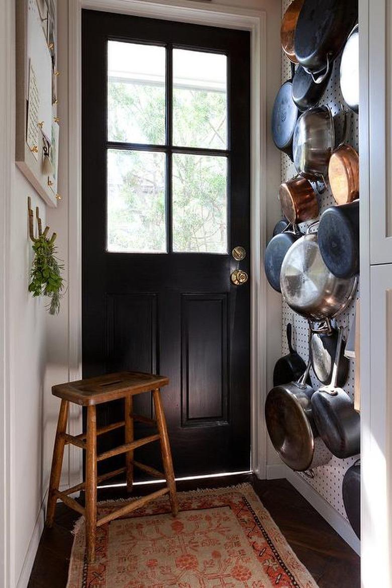 pots and pans hanging on a pegboard