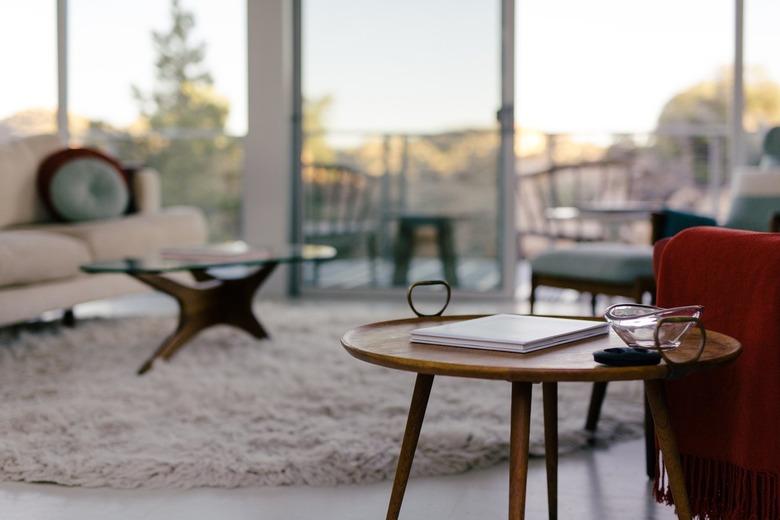 a view of the desert through large windows and a room full of mid-century furniture