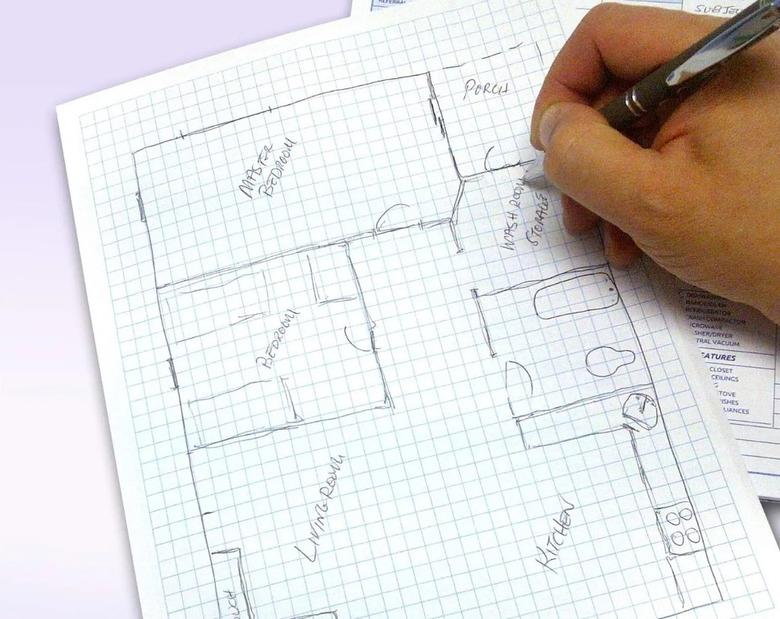 Sketching a  house plan on graph paper.