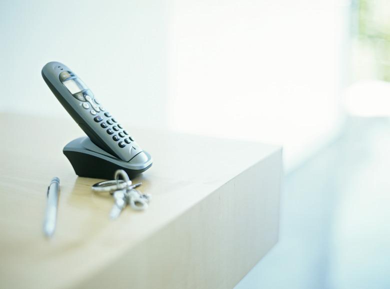 Cordless phone on table by keys and pen,differential focus