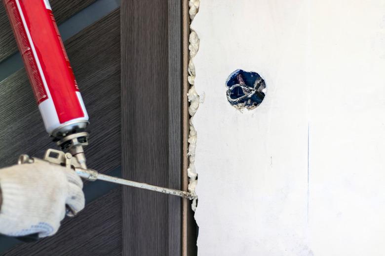 A master installing a door block using polyurethane foam in the room.