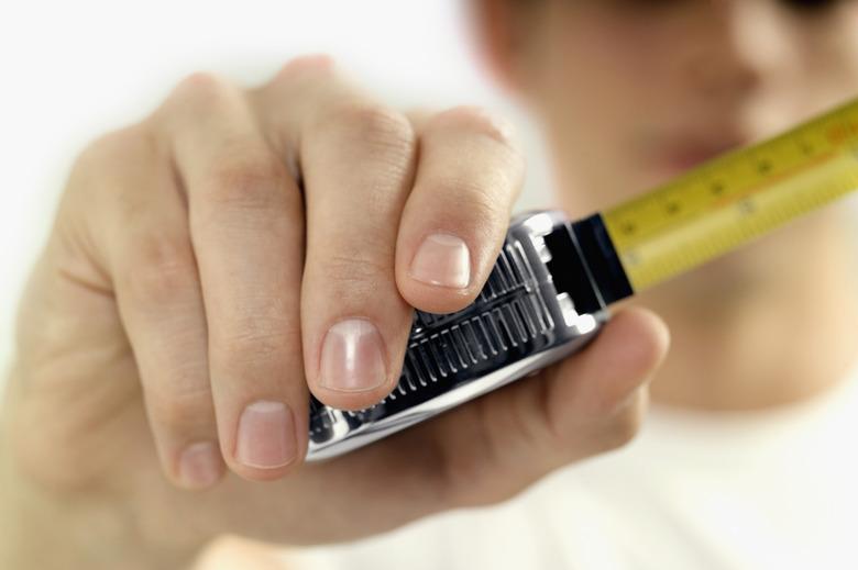 Man holding measuring tape, close-up, selective focus