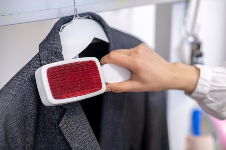 Womans hand easily thoroughly cleaning jacket with brush