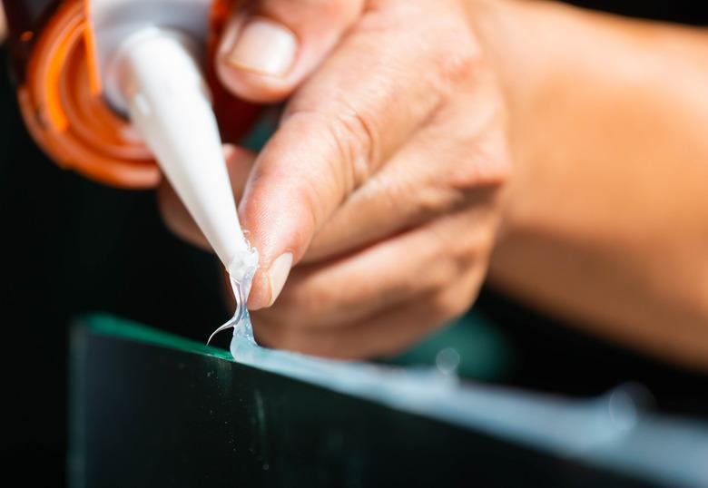 Using silicone adhesive to glue a mirror to aluminum.