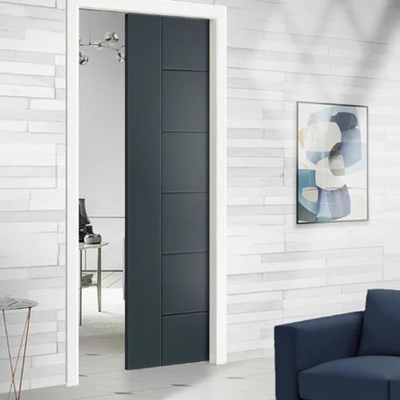 A dark pocket door installed in a room with light walls