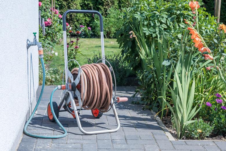 Coiled garden hose on a cold water pipe.