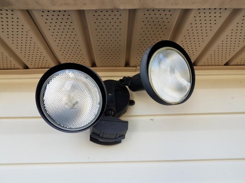 Motion sensor flood light on white home siding