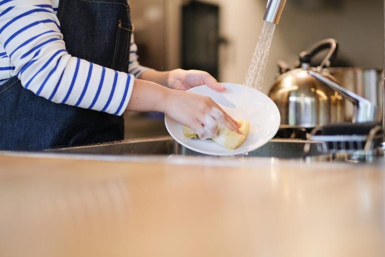 Waitress washing dish in the kitchen of restaurant