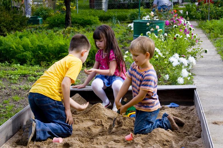 Kids playing in sandbox.