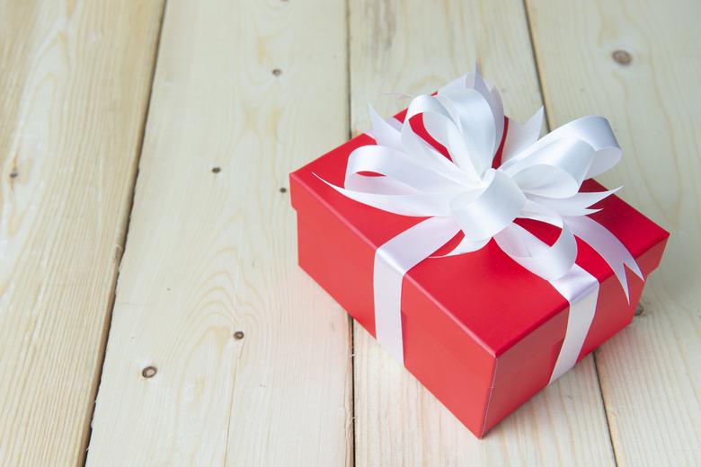 Red gift box seasoning crebration decoration on clean wooden background.