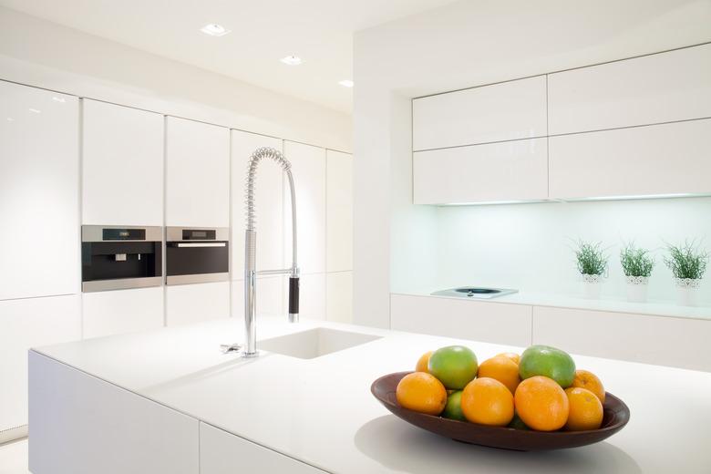 Fruit in a bowl, pristine white kitchen.