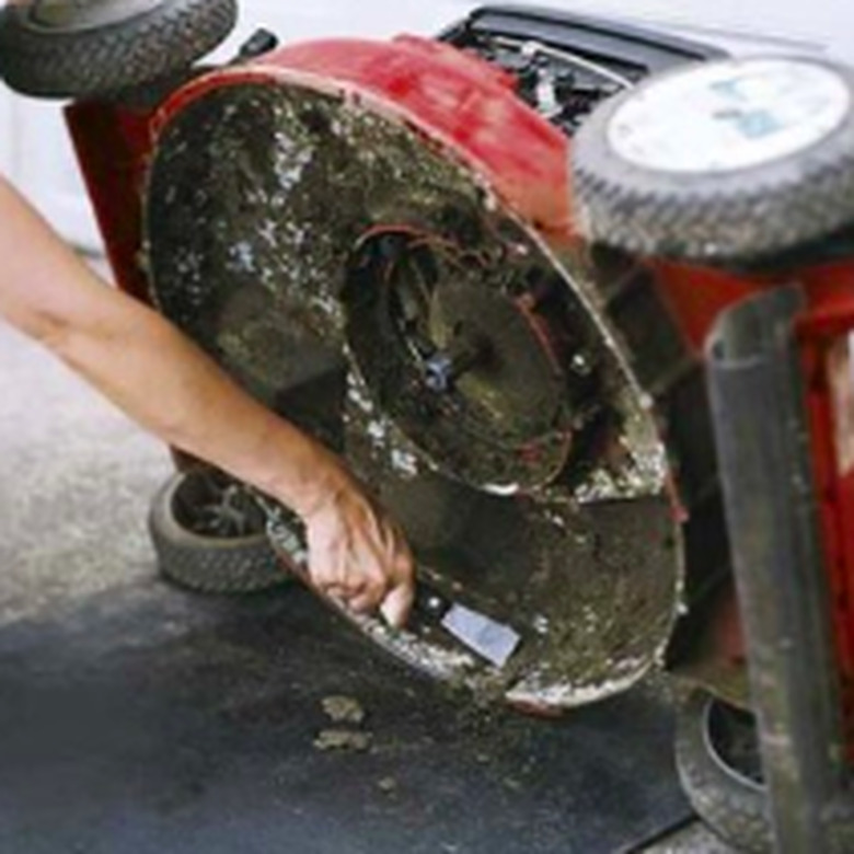 Cleaning a lawnmower.