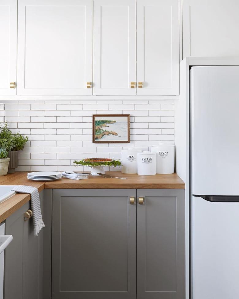 two-tone cabinet kitchen trend in 2019 with white subway tile backsplash and wood countertops