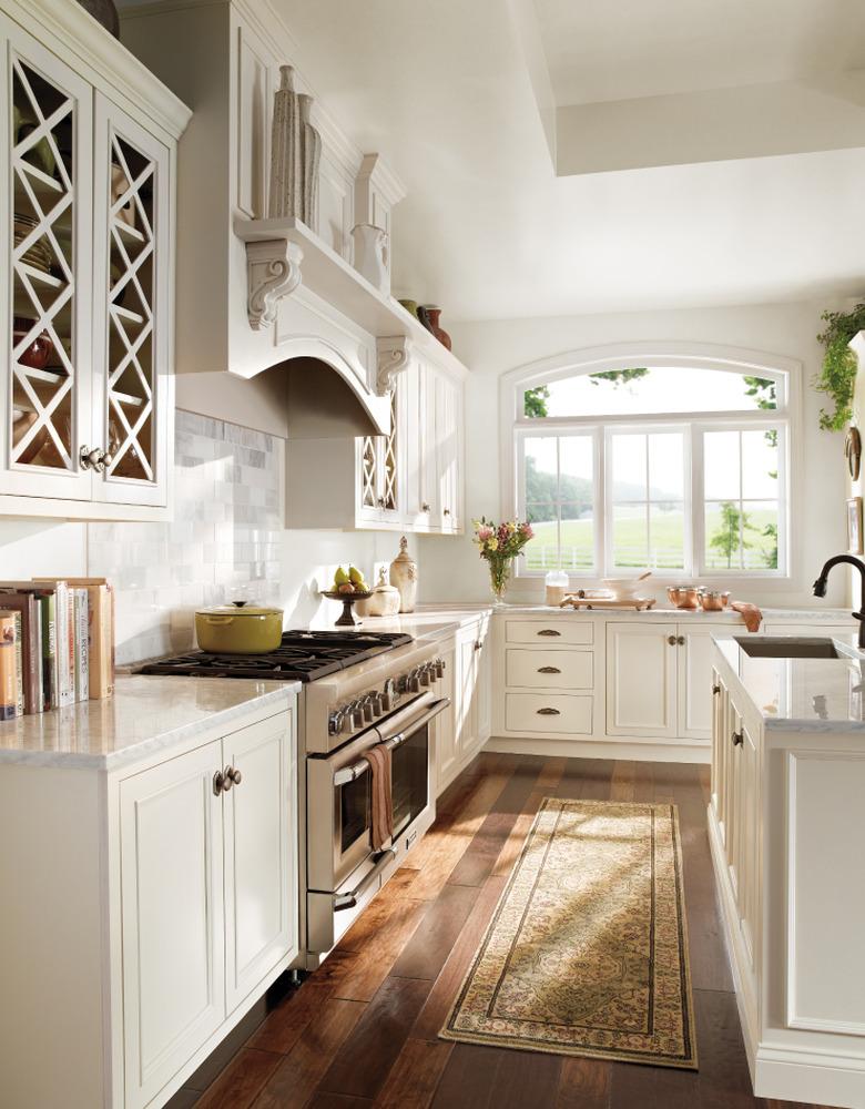 Farmhouse kitchen with off-white walls trim and cabinetry, and two-tone wood floors.