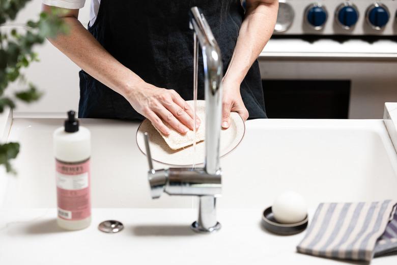 cleaning dish at kitchen sink