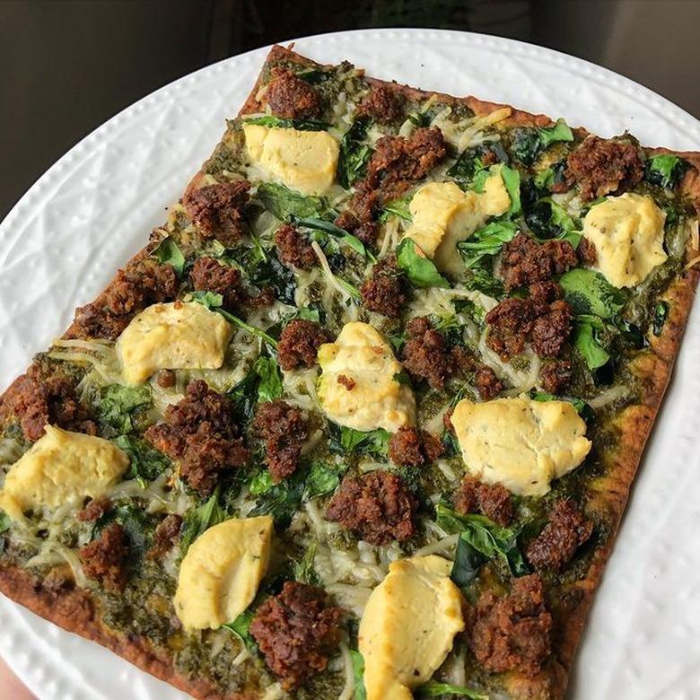 pesto flatbread on white plate using impossible meat