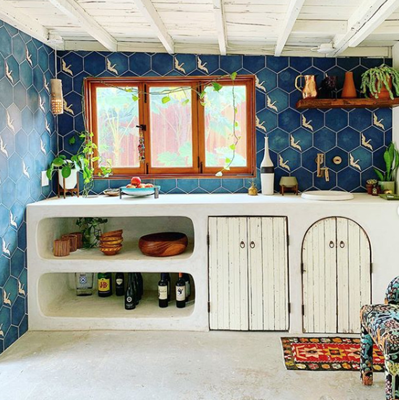 bohemian kitchen color idea with blue wall tile and white countertop and cabinets