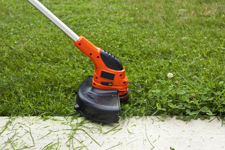 Weed Trimmer Trimming Grass Along Sidewalk