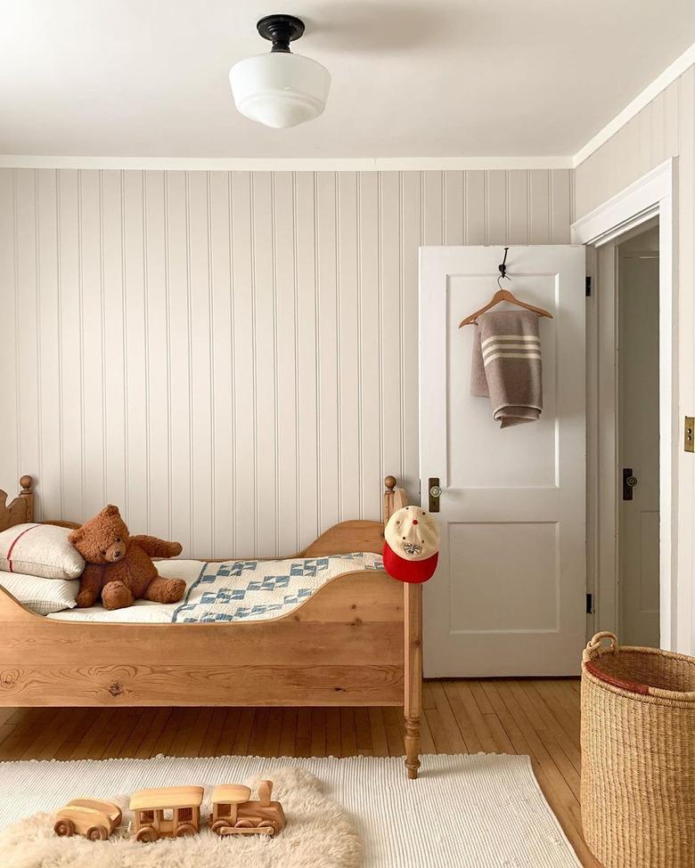 Kids' minimalist bedroom with wood bed and vintage decor