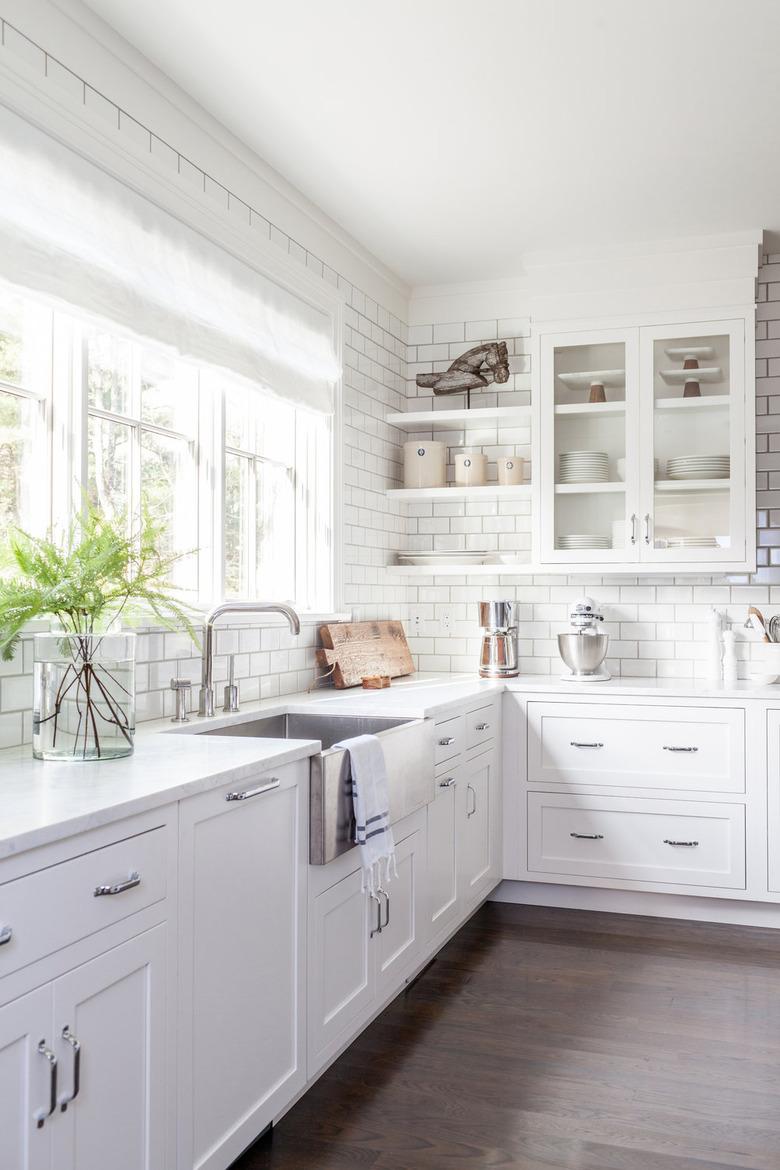 kitchen cabinet style with white glass front upper cabinets and white lower cabinets with white subway tile backsplash