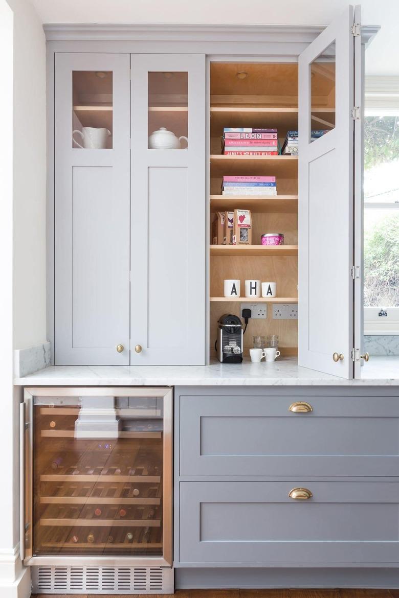 Kitchen with gray cabinets, old hardware and a built-in wine cooler.