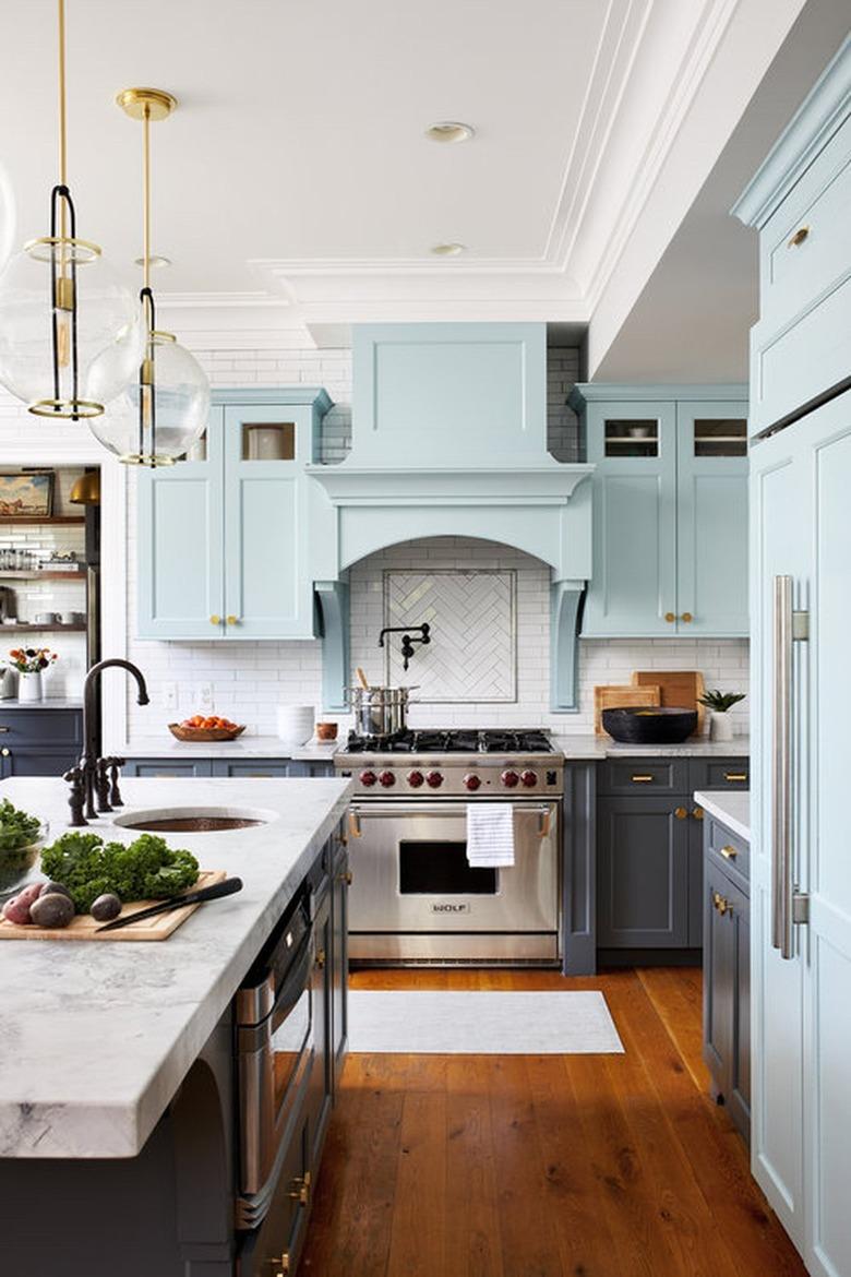 kitchen island sink in farmhouse space with blue cabinets and marble countertop