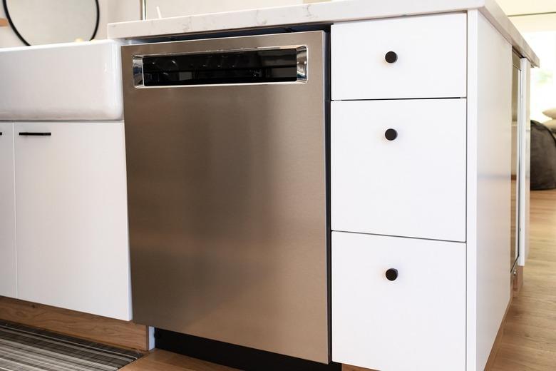 white kitchen cabinets with black hardware and stainless steel dishwasher