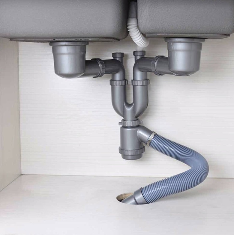 Pipes under sink connected to drain pipe.