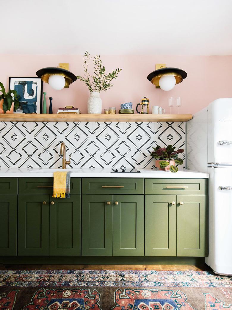 contemporary black and brass wall sconces in green and pink kitchen