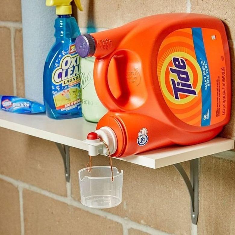 tide detergent bottle on shelf with plastic detergent cup hanging off it