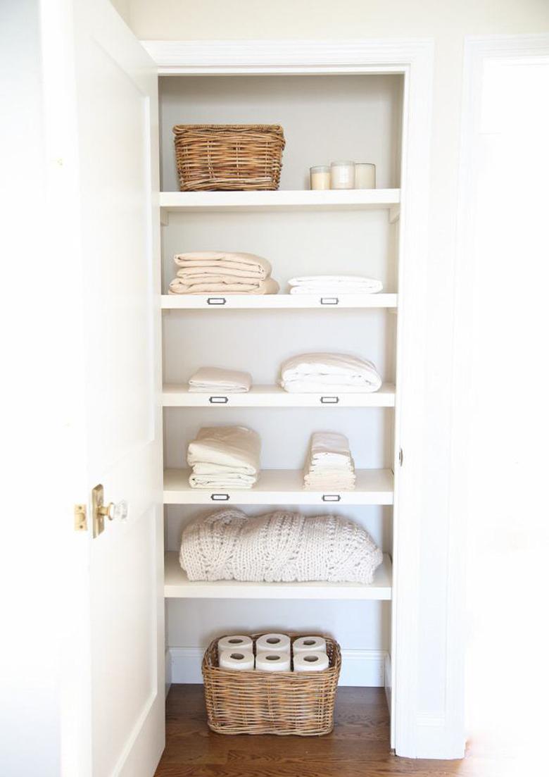 linen closet organization with labeled shelves and woven baskets