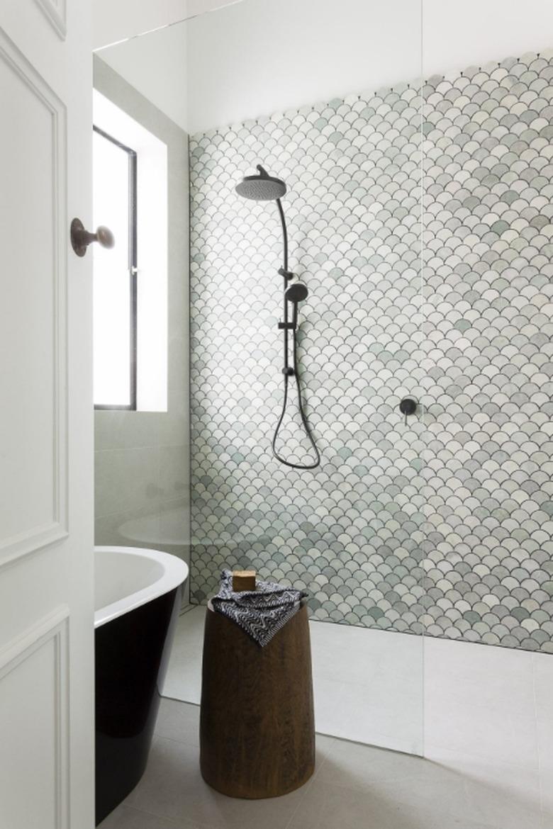 fan-shaped mosaic tile accent wall in green bathroom