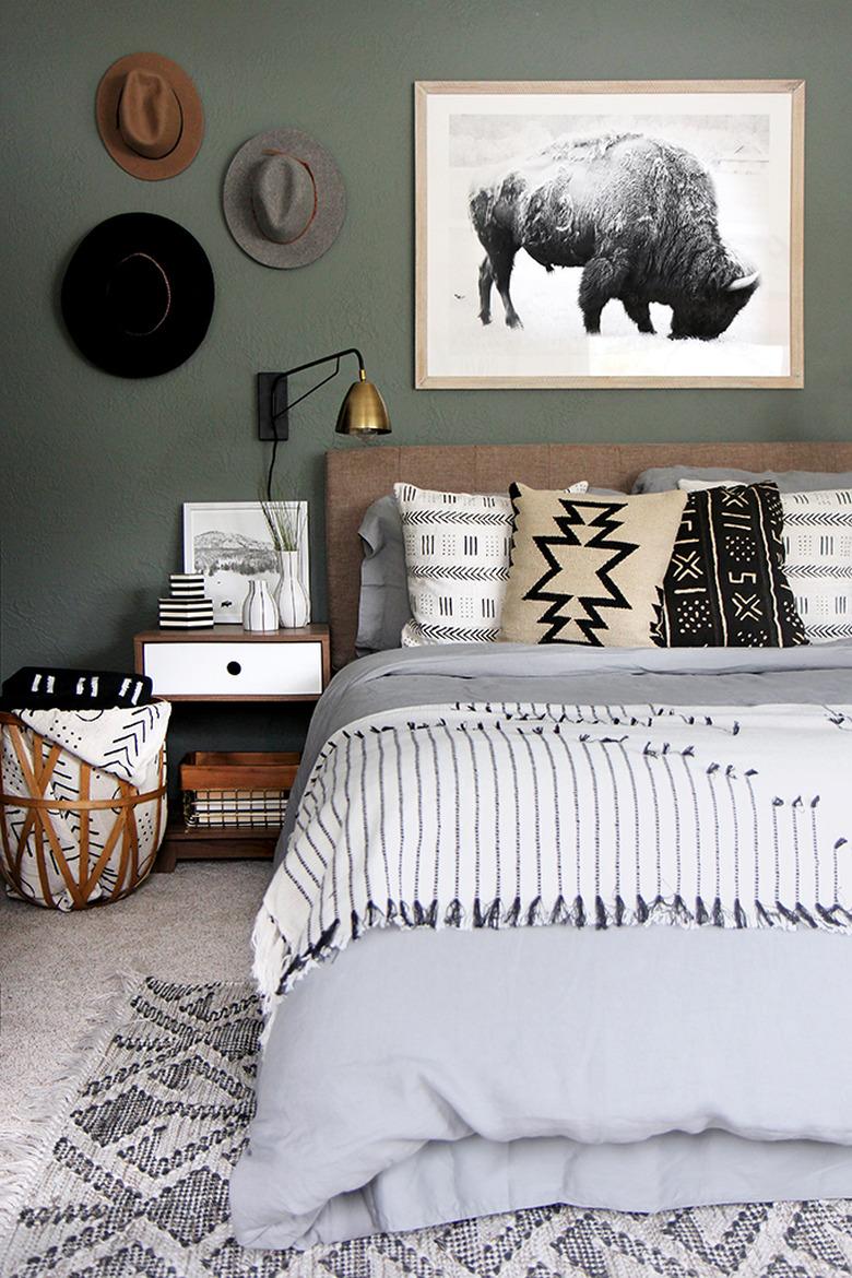 masculine boho bedroom with hats as art and neutral bedding