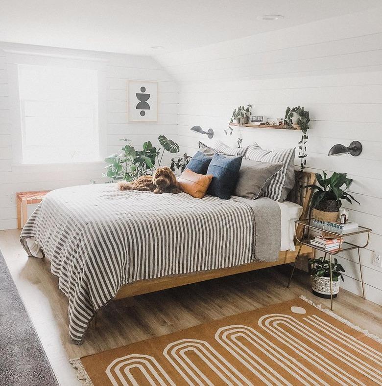 masculine boho bedroom with striped duvet and patterned rug