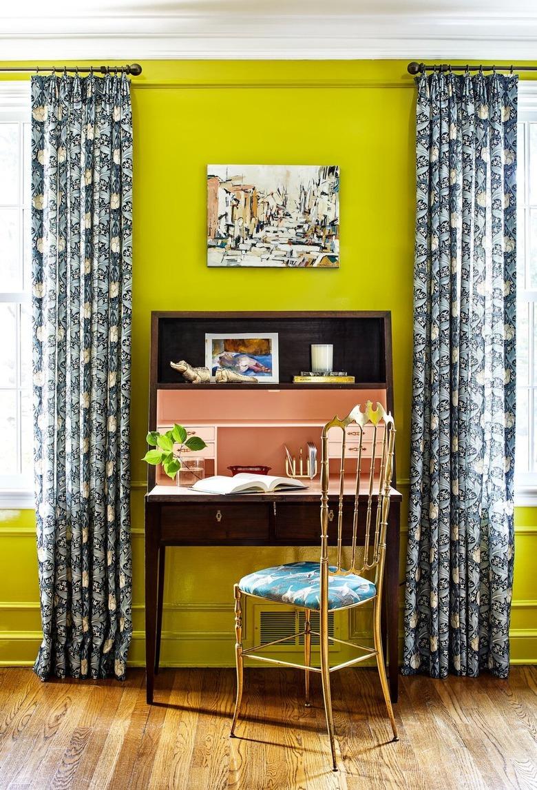 chartreuse maximalist home office with blue patterned curtains and wooden secretary desk