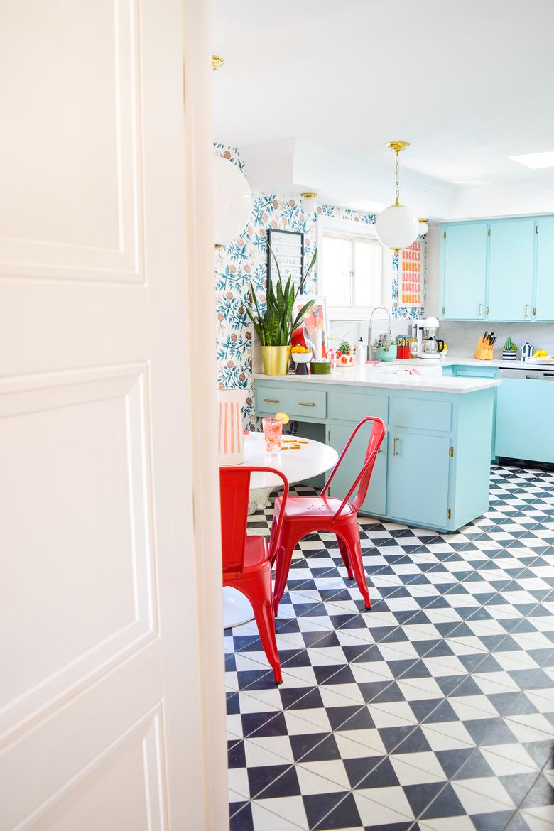 retro colorful maximalist kitchen with blue cabinets and checkerboard flooring