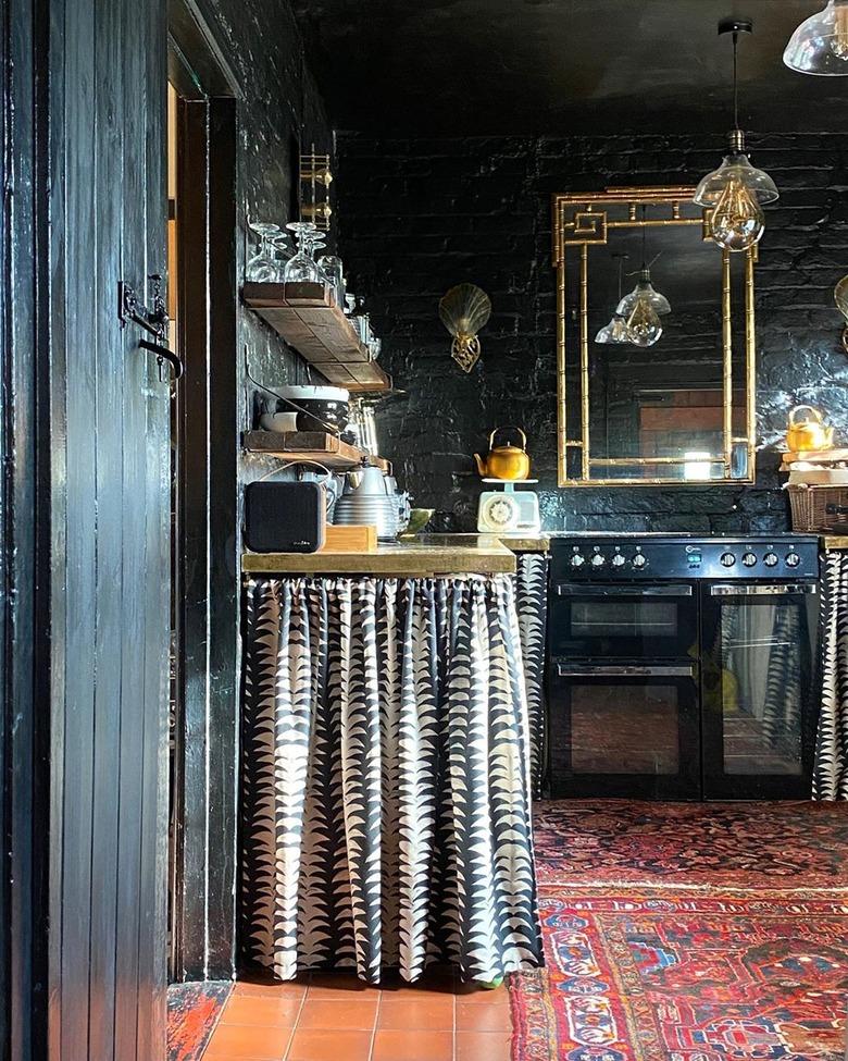 maximalist kitchen with dark walls and skirted cabinets