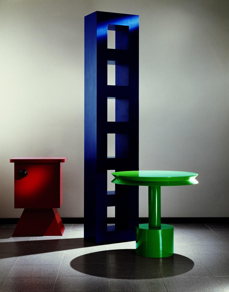 three pieces, one red short piece, tall blue piece, and green table, in Memphis Design style, designed by Aldo Cibic