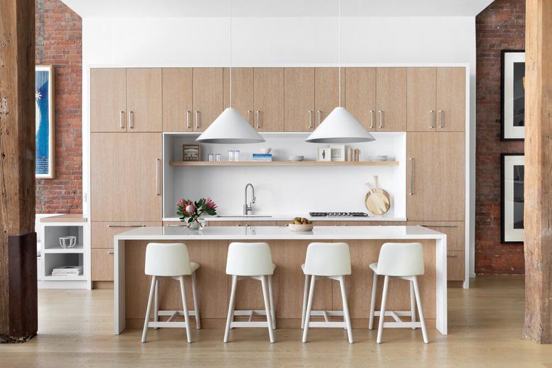 kitchen with light wood, white chairs and white lighting fixtures