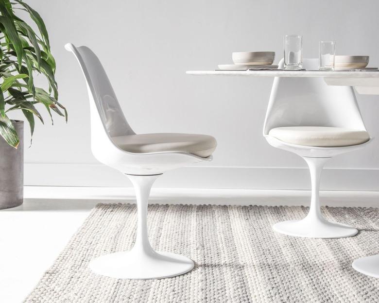 Minimalist dining room idea with Eero Saarinen table with white tulip chairs on textured rug