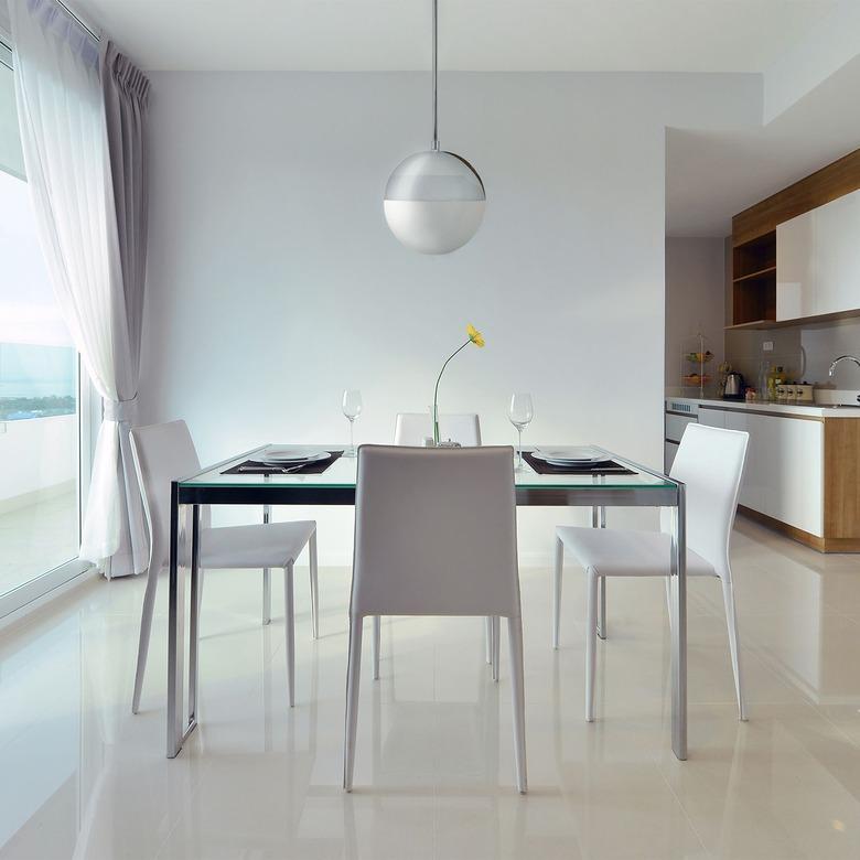 Minimalist dining room idea with chrome globe pendant light in white dining room with white chairs