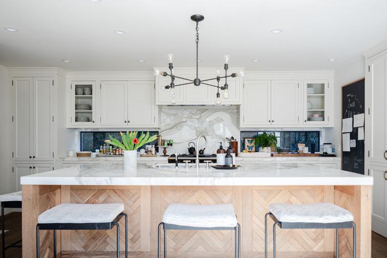 kitchen island with white stone countertop and modern pendant light