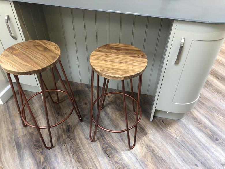 Dark oak effect laminate floor with light-blue kitchen island, oak-top stools.