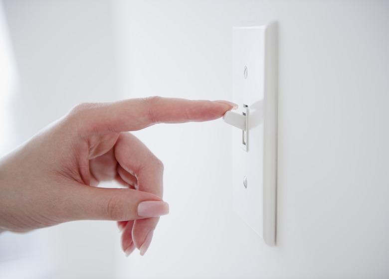 Korean woman turning off light switch